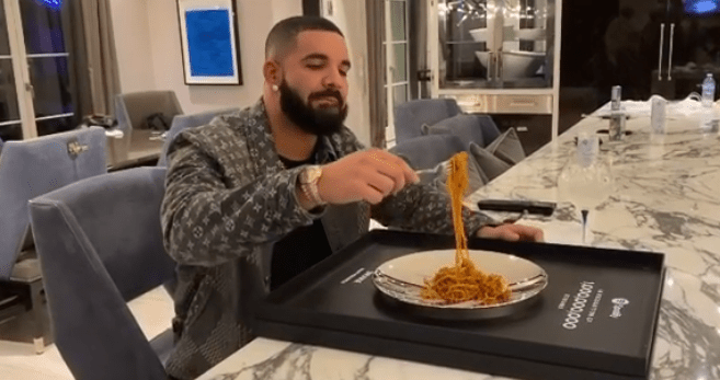 Drake celebra comendo macarrão encima de placa conquistada no Spotify